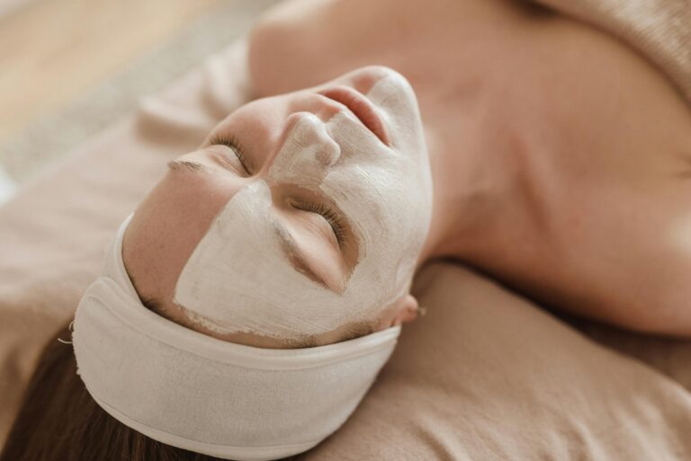 A serene woman enjoying a skincare treatment with a facial mask at a spa.